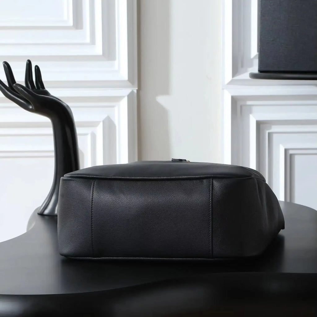 Bolsa de ombro grande em couro preto de grão macio, com alça larga ajustável e design aberto.