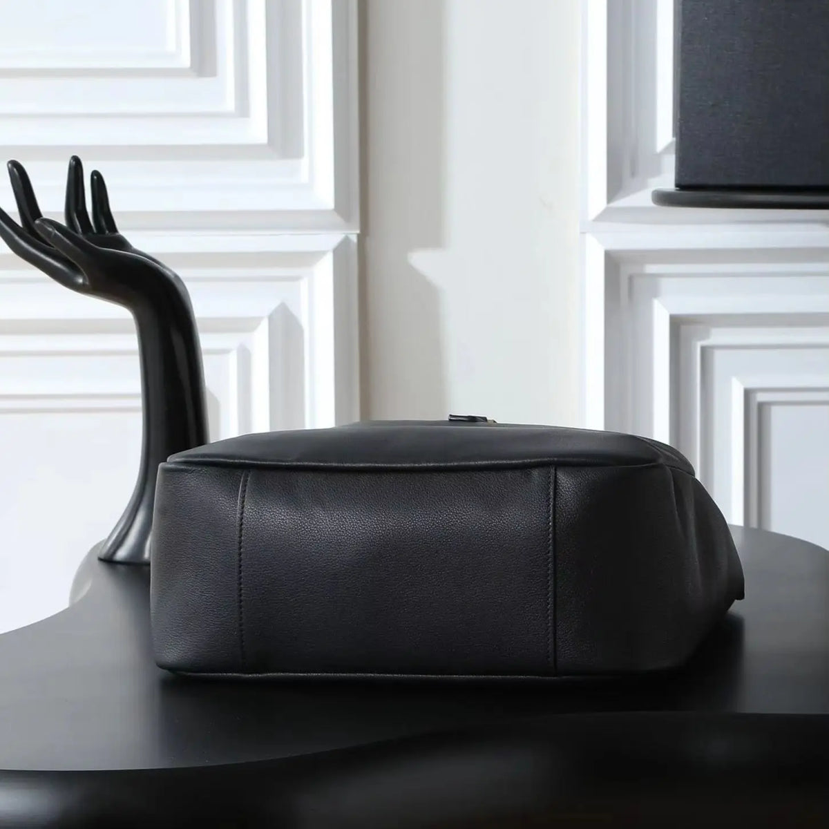 Bolsa de ombro grande em couro preto de grão macio, com alça larga ajustável e design aberto.